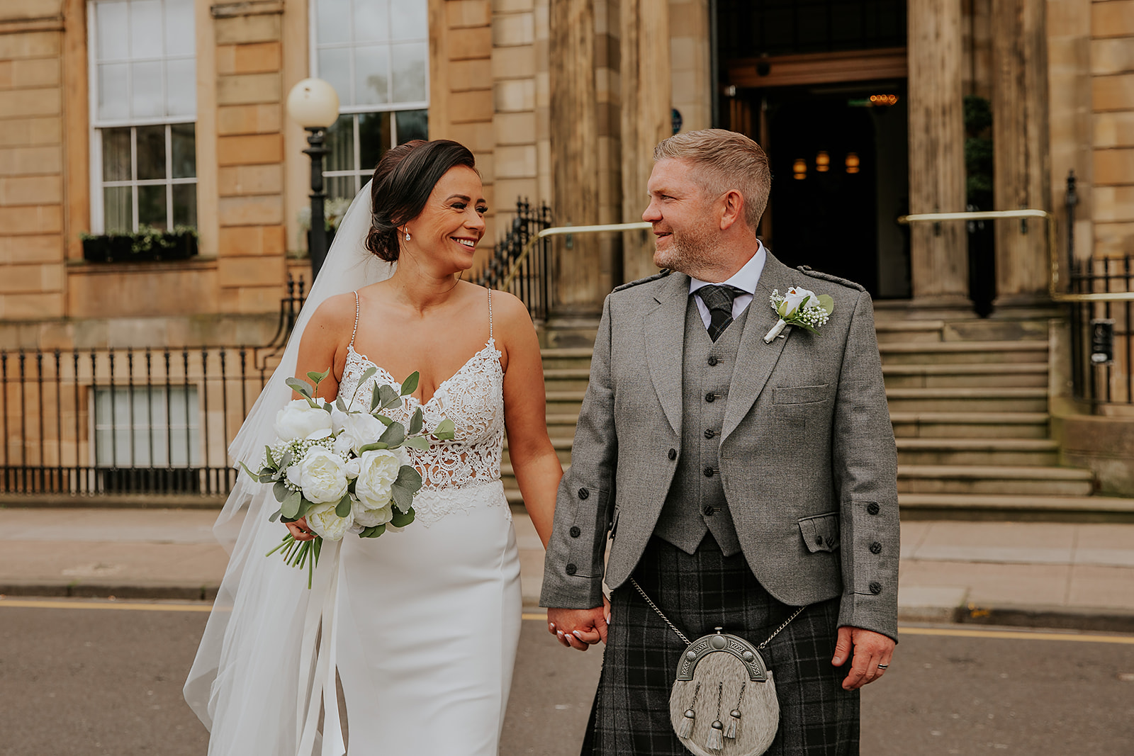 Couple smiling and walking outside Kimpton Blythswood Hotel