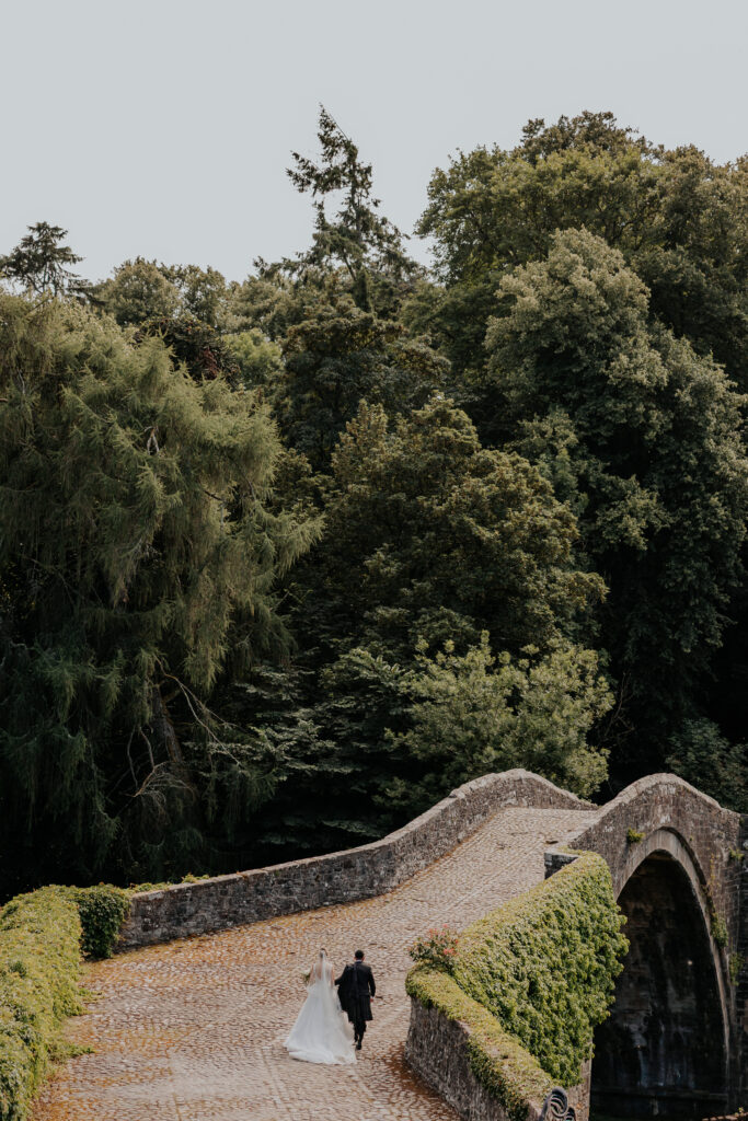 Couple standing on iconic brig o doon bridge from distance