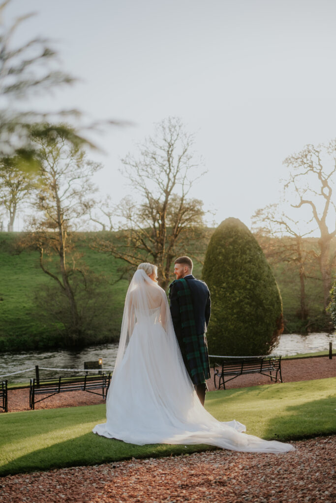 Golden hour with couple standing in the gardens of brig o doon